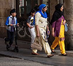 Two women and two children walking along a street